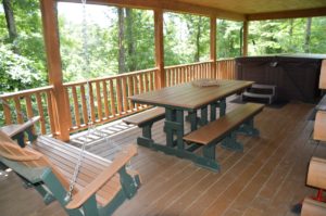 deck with porch swing and picnic table at Escape log cabin