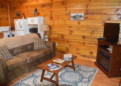 TV area with sofa in The Landing log cabin
