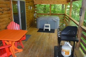 deck with gas grill and hot tub at The Overlook log cabin