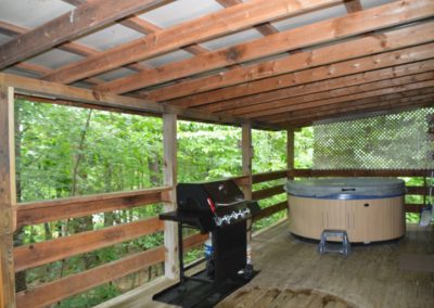back porch with hot tub on porch of The Lakota log cabin