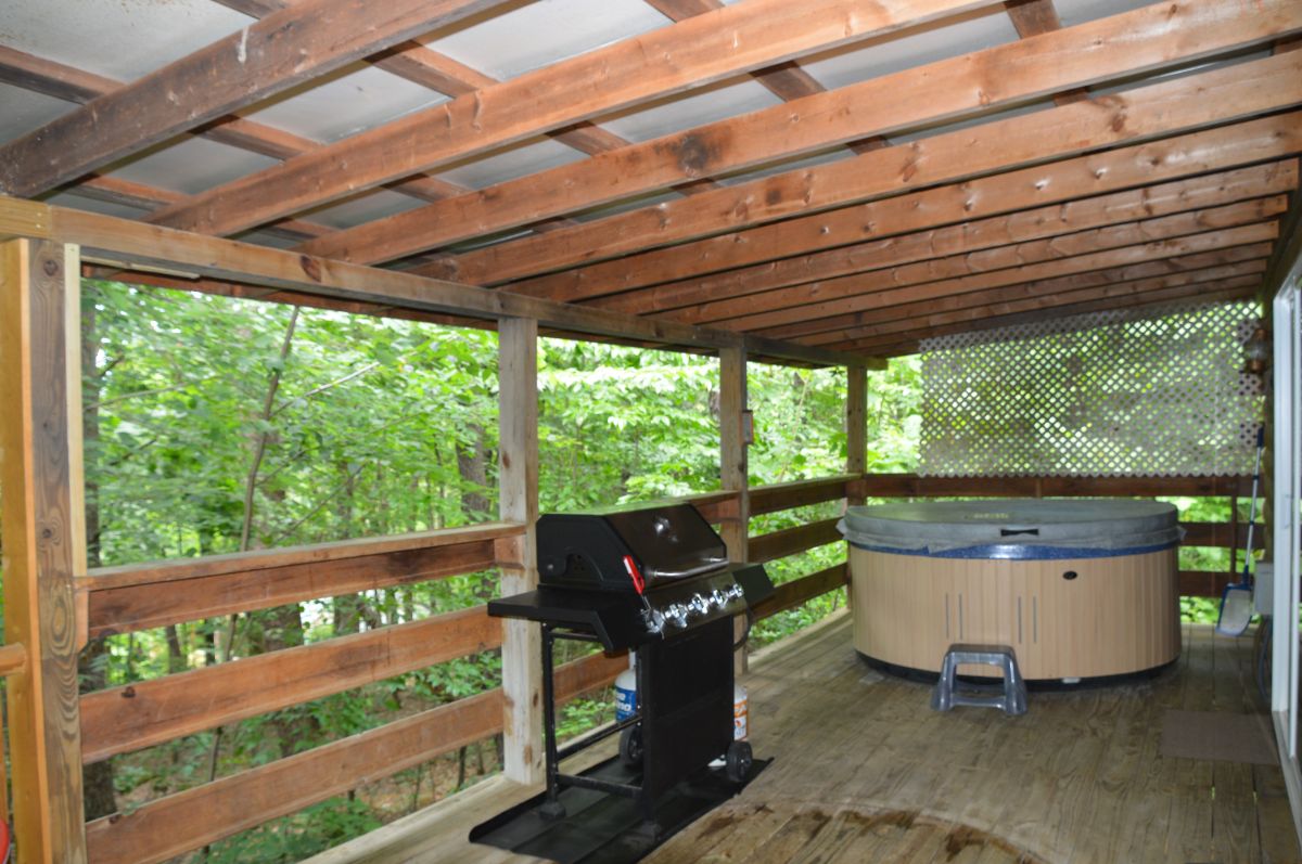 back porch with hot tub on porch of The Lakota log cabin